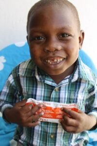 Kleiner Junge in Haiti mit der Spezialnahrung