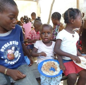 Kinder in Haiti bekommen eine Mahlzeit in der Kindertafel